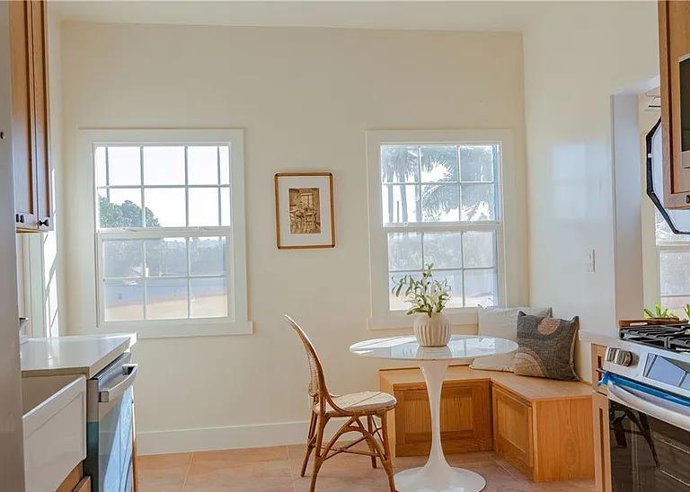 Breakfast nook with a built-in wood banquette and a round table by Jill Seidner Interior Design