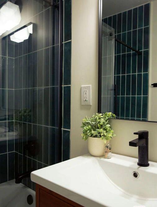 Bathroom with green vertical tile and a white vanity by Jill Seidner Interior Design