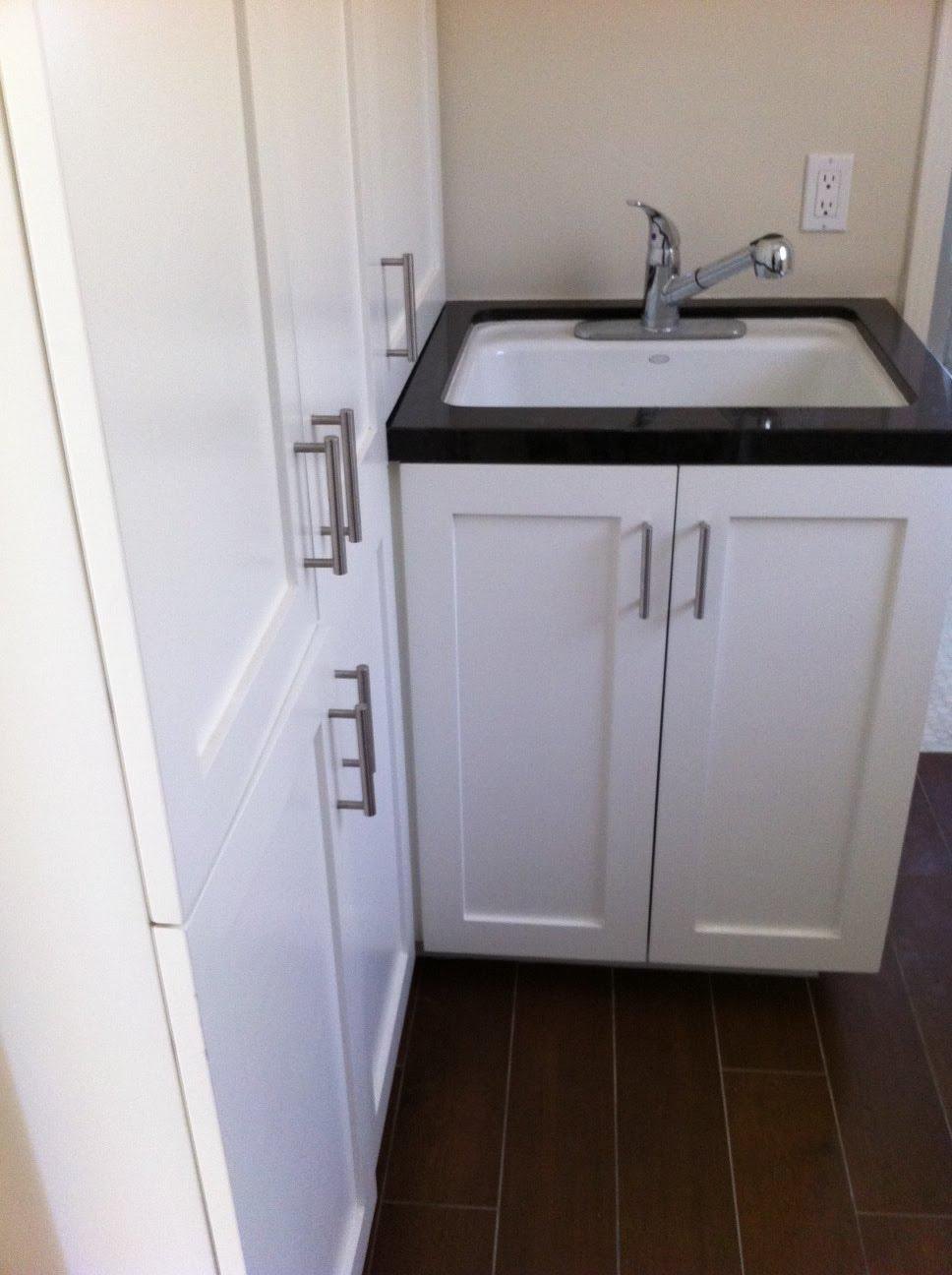 Laundry room with white cabinets and a sink by Jill Seidner Interior Design
