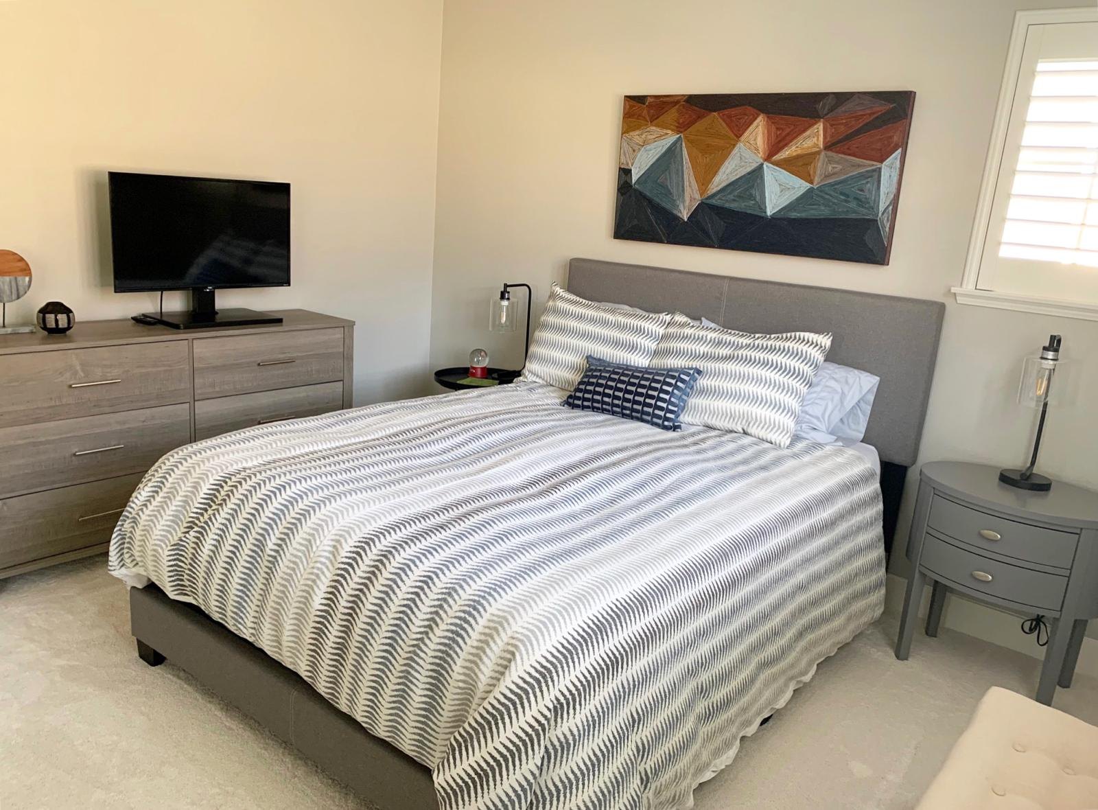 Bedroom with a striped duvet and art by Jill Seidner Interior Design