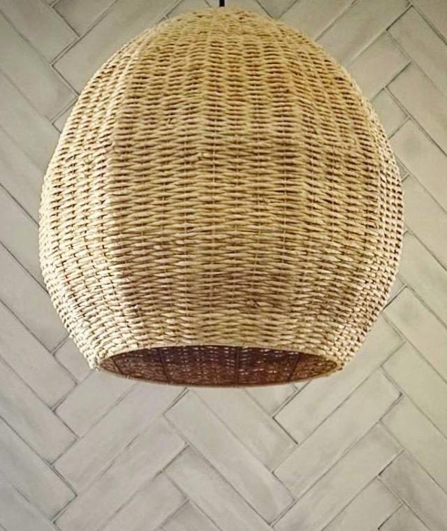 Primary bathroom rattan pendant over a herringbone tile wall by Jill Seidner Interior Design