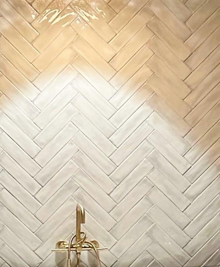 Primary bathroom herringbone tile wall with a brass tub filler by Jill Seidner Interior Design