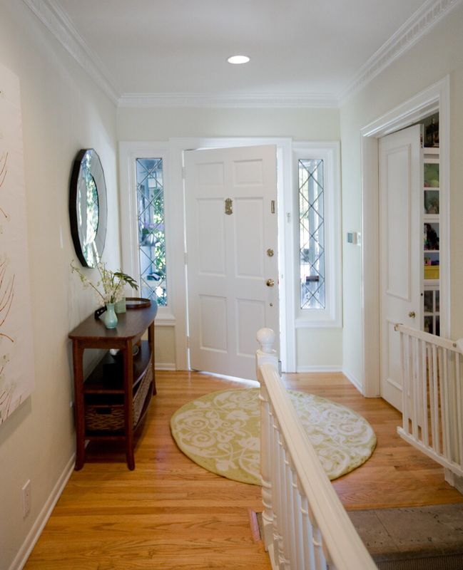 Welcoming entry hall with wood console and round rug, moving day interior design services