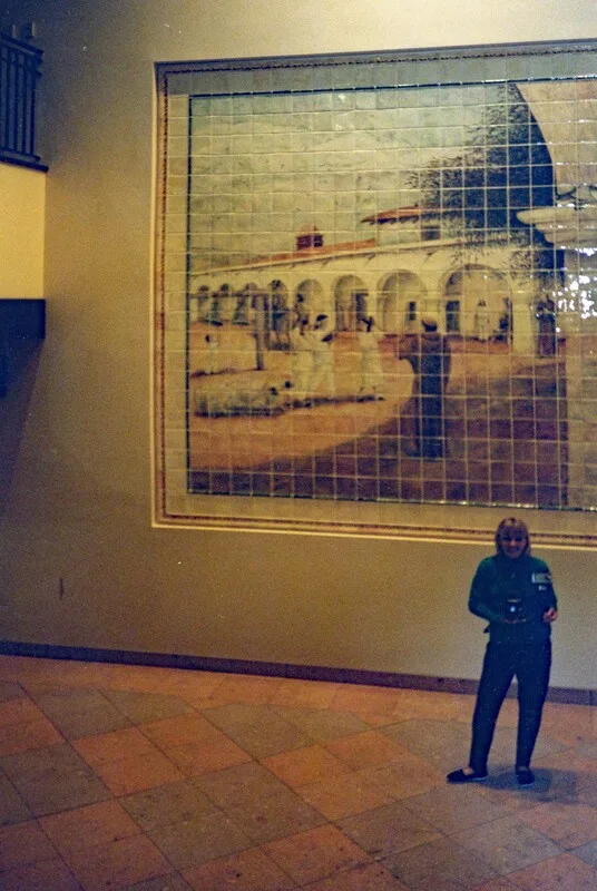 Photographer standing next to the newly finished "Mission San Juan Capistrano Mural" by artist Jamie Santaniello.  The photographers  figure gives a good sense to the size of the mural.