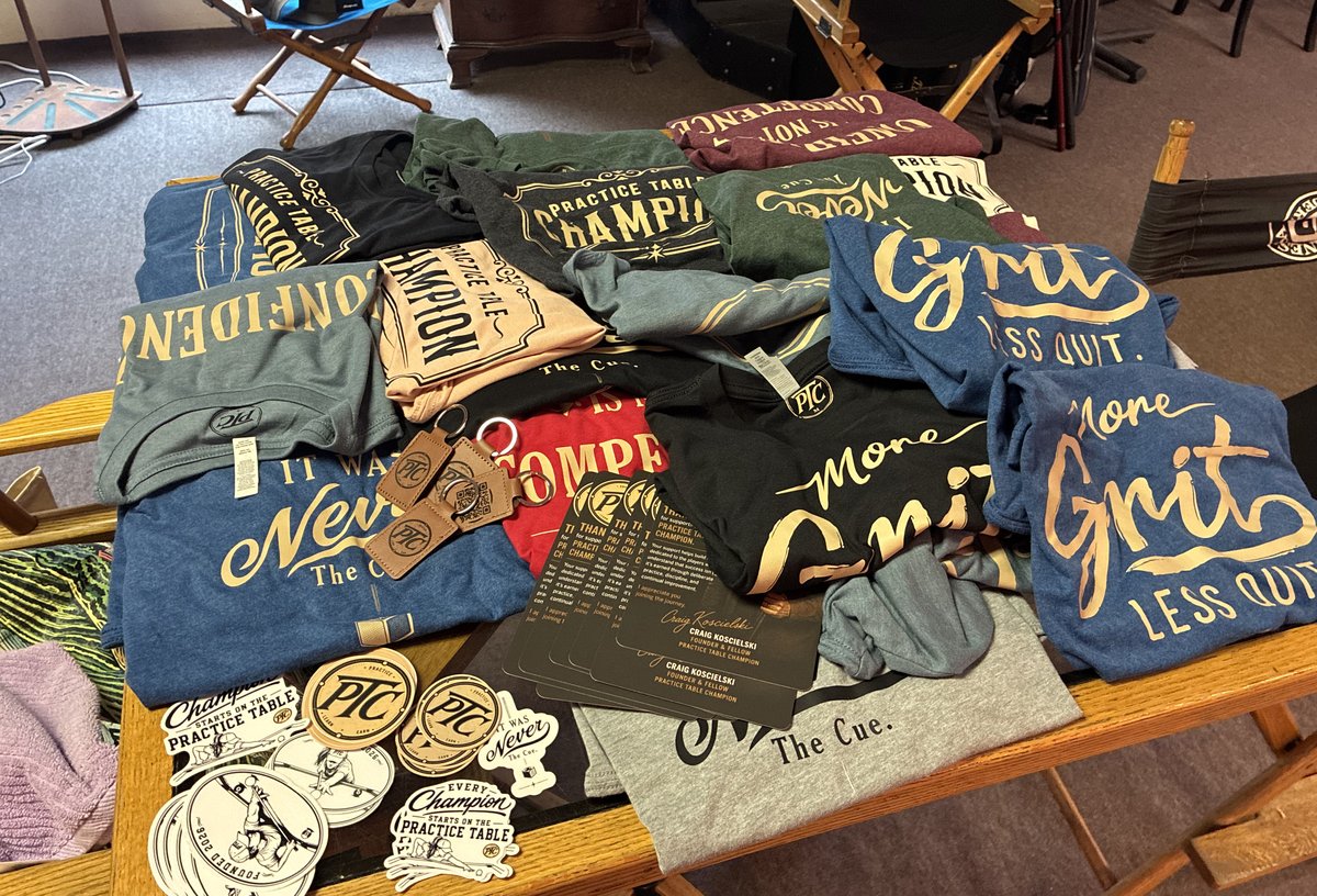 Shirts, stickers, cards and keychains set out together.