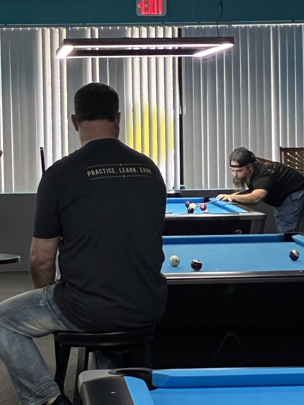 Brian Berry watches Nicholas Allaire at the table during a tournament at Capital City Billiards in Concord, New Hampshire.