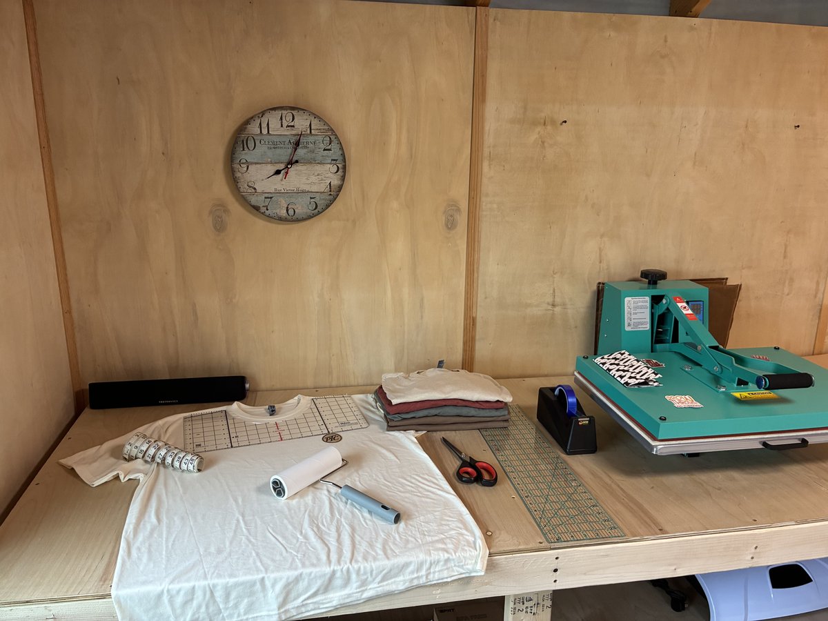 A shirt, alignment ruler and preparation tools beside the press.