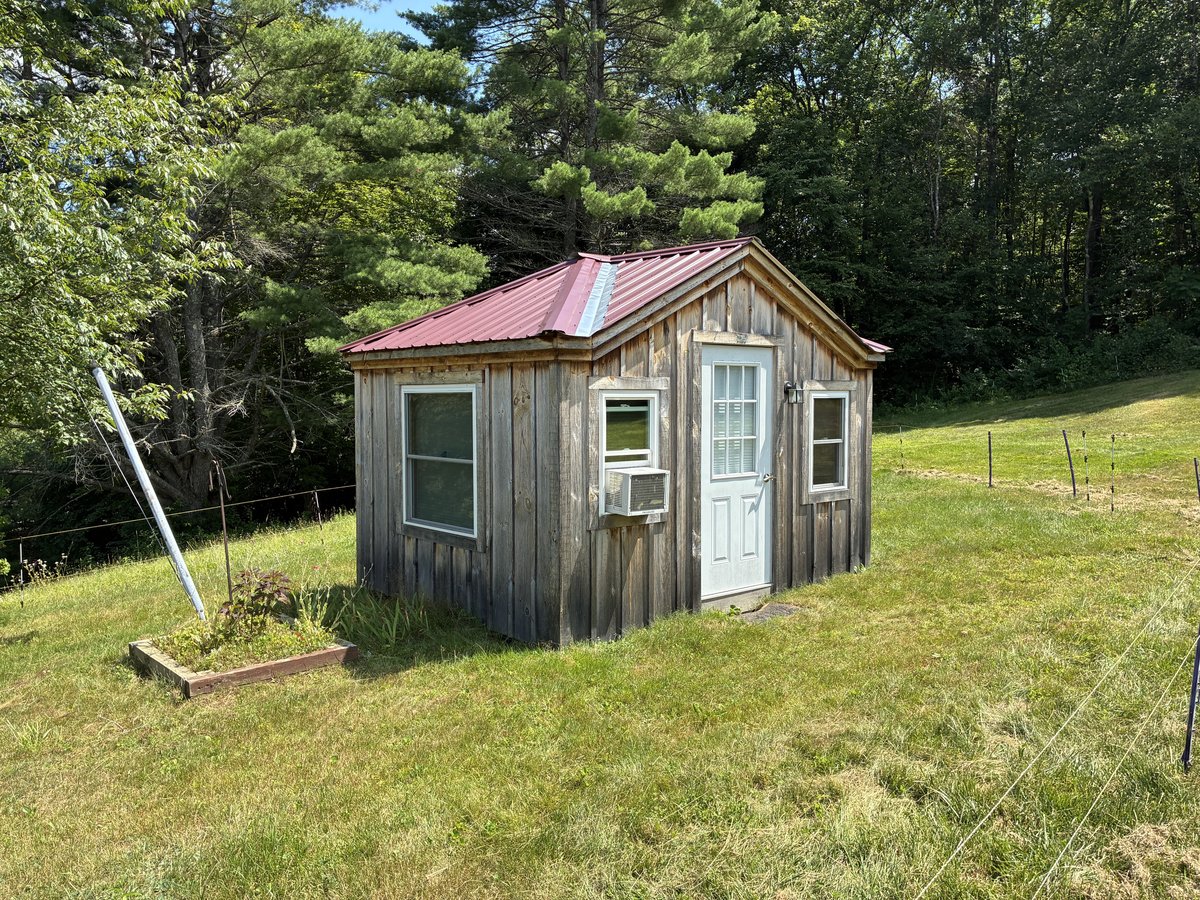 The wood-sided workshop and its red roof.
