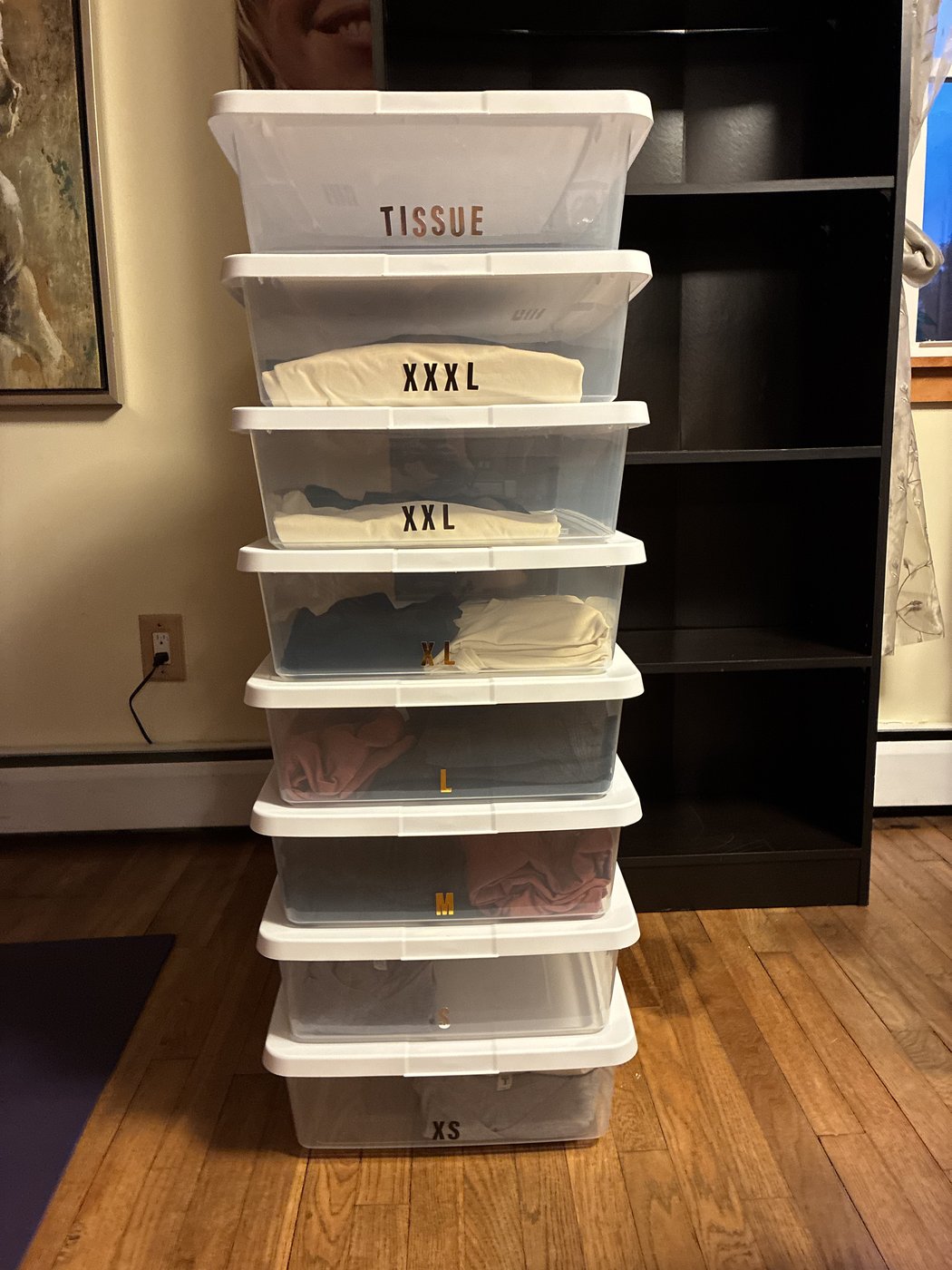 Clear storage bins organized with size labels.