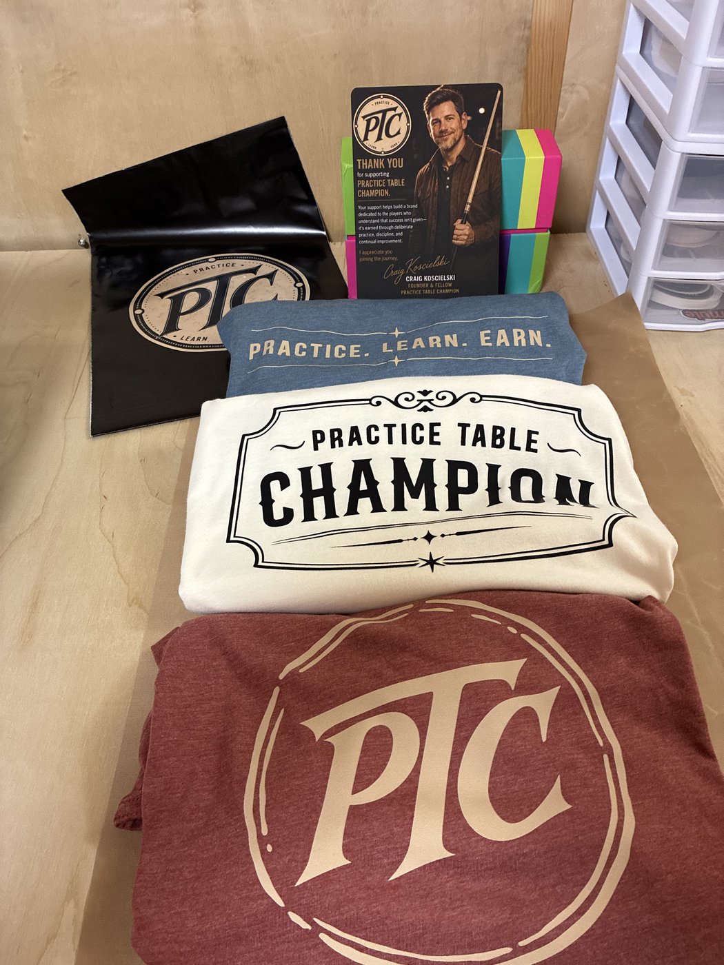 Folded shirts, a PTC mailer and a printed thank-you card.