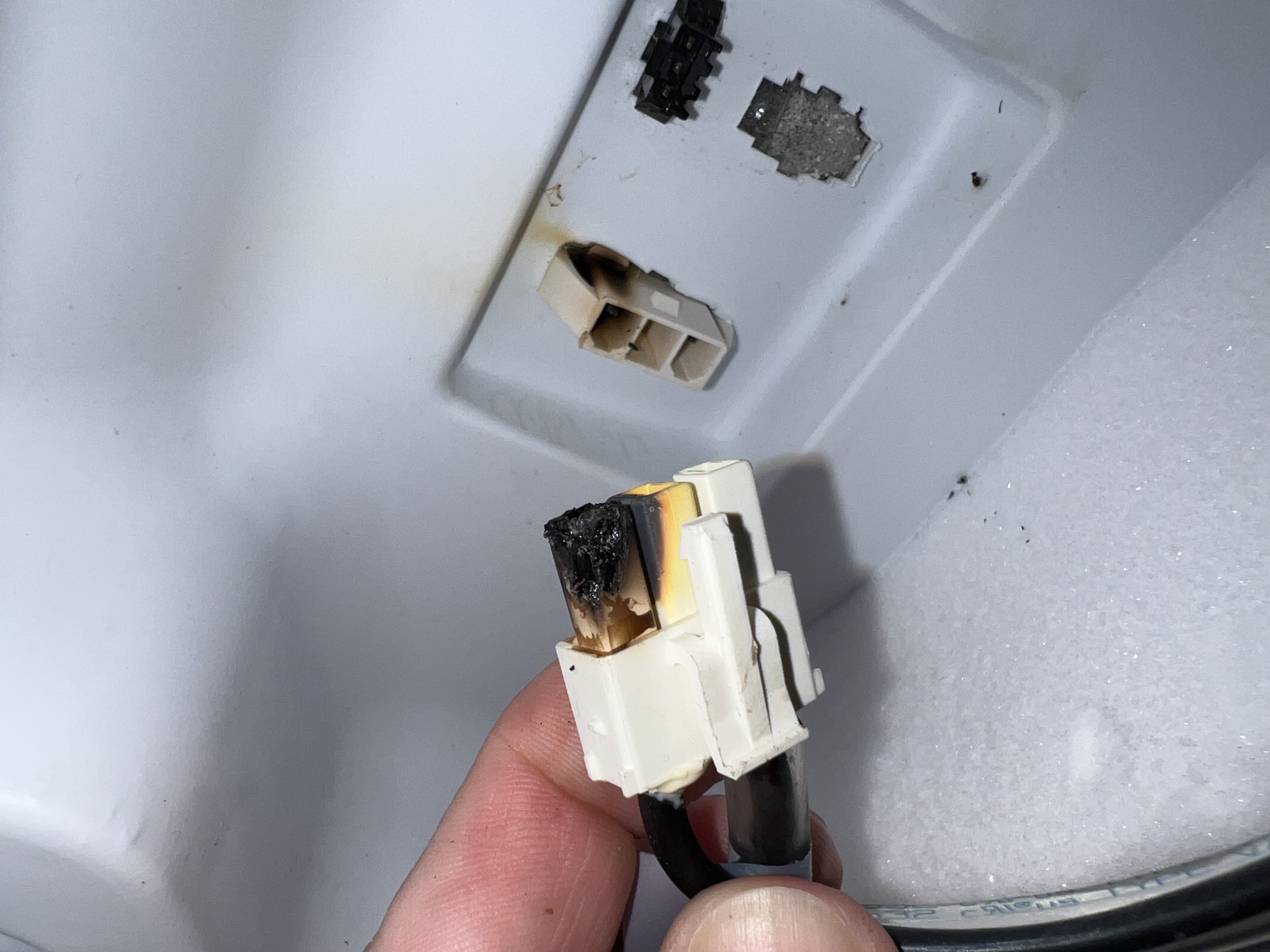 The burnt defrost heater plug, removed for inspection