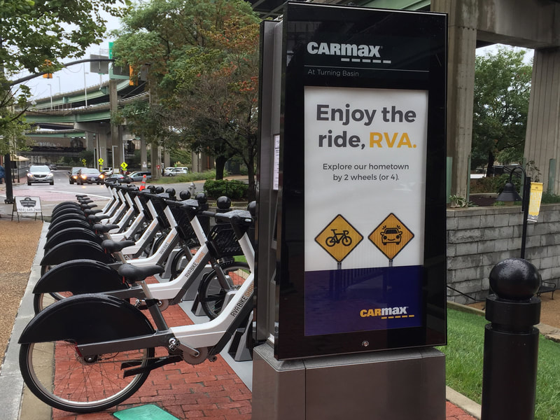 RVA Bikeshare station poster outside a CarMax office location.