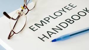 Employee handbook with pen and reading glasses on it.