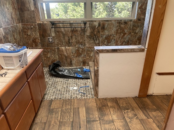 Complete bathroom transformation featuring new walk-in shower with floor-to-ceiling tile, replacement of outdated glass block window with modern double-hung windows. Spacious, modern design.