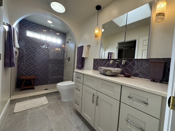 Guest bathroom renovation featuring modern shower enclosure, custom vanity with onyx sink, updated tile work, and new glass block window. Complete refresh with quality finishes throughout.