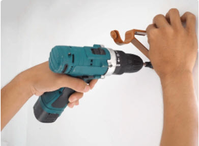 Image showing someone installing a hook representing handyman services in Santa Fe NM area