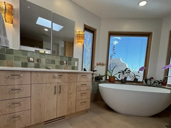 image showing bathroom remodel in Eldorado at Santa Fe NM  area featuring new custom maple cabinets, with dual sinks, and Cambira quartz countertops and standalone soaking tub. 