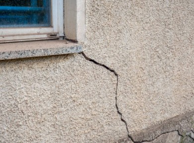 mage showing a medium sized crack in a stucco wall meant to describe contractor  stucco repair services in Santa Fe NM area
