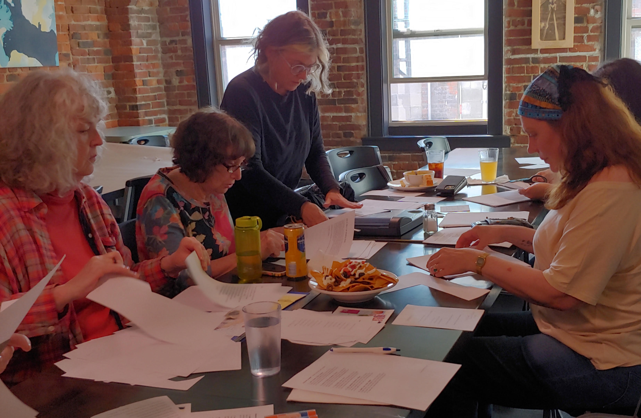 People sitting at a long table working with papers.