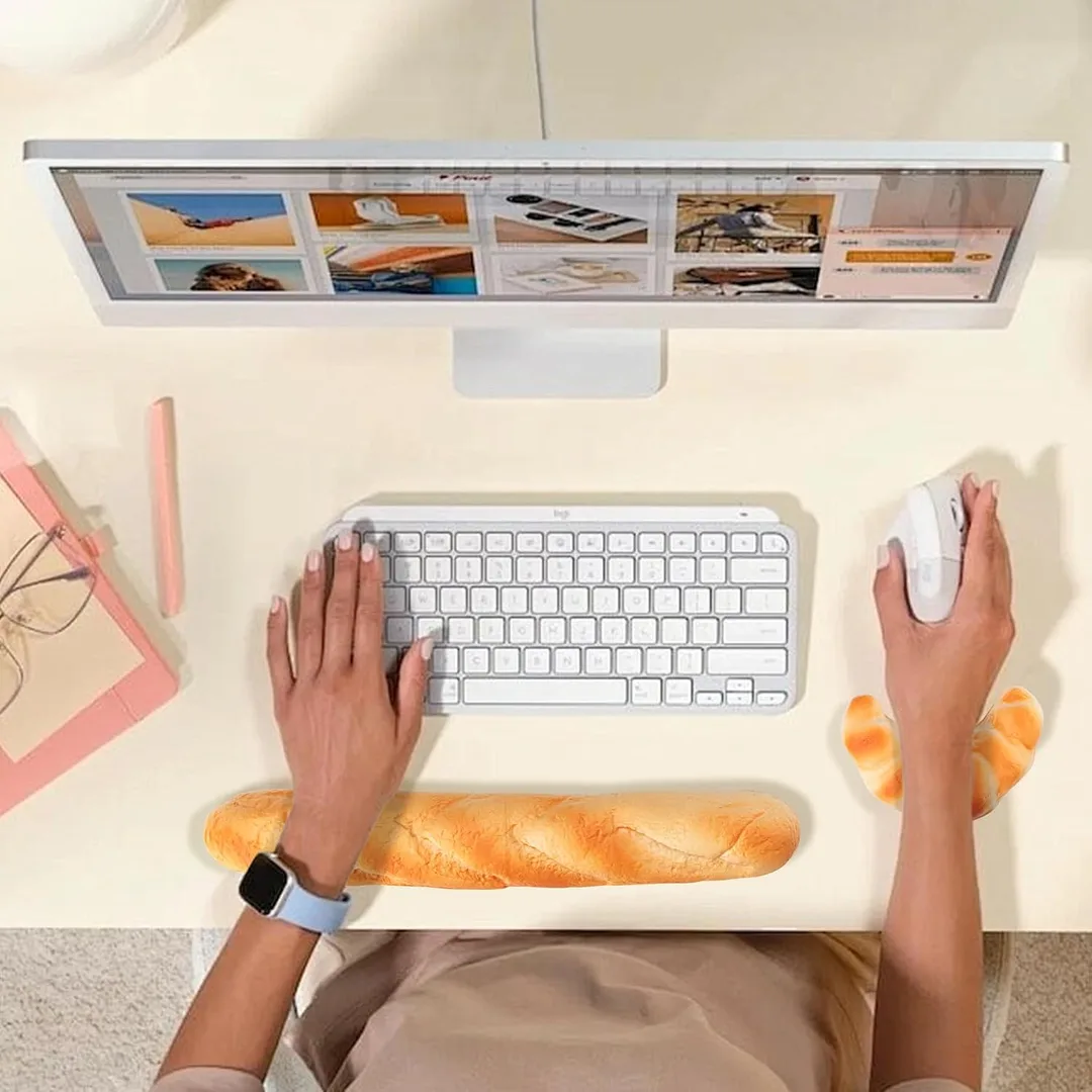 A person putting the baguette shaped wrist rest and croissant mouse wrist rest to work.