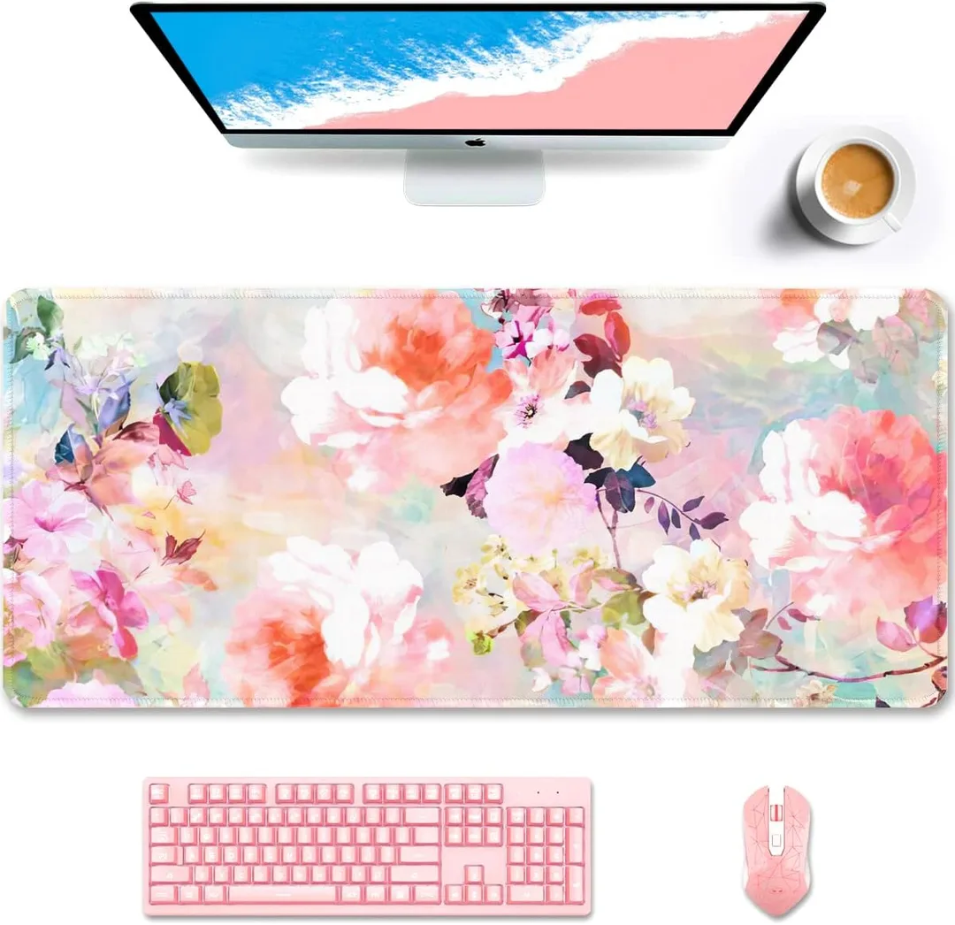 A floral desk mat on a white desk with a cup of coffee.