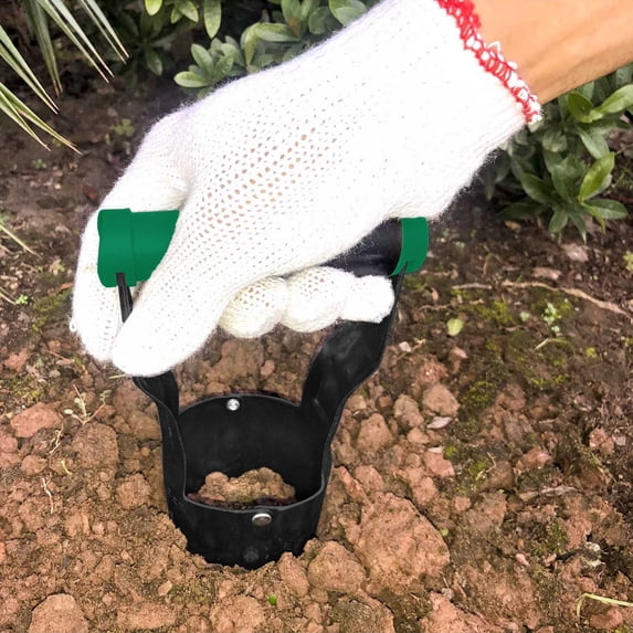 A handheld bulb planter being pushed into soil.