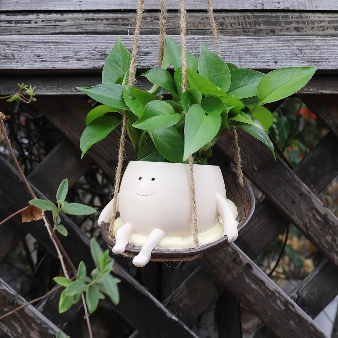 Hanging smiley face swing planter outside on a deck.