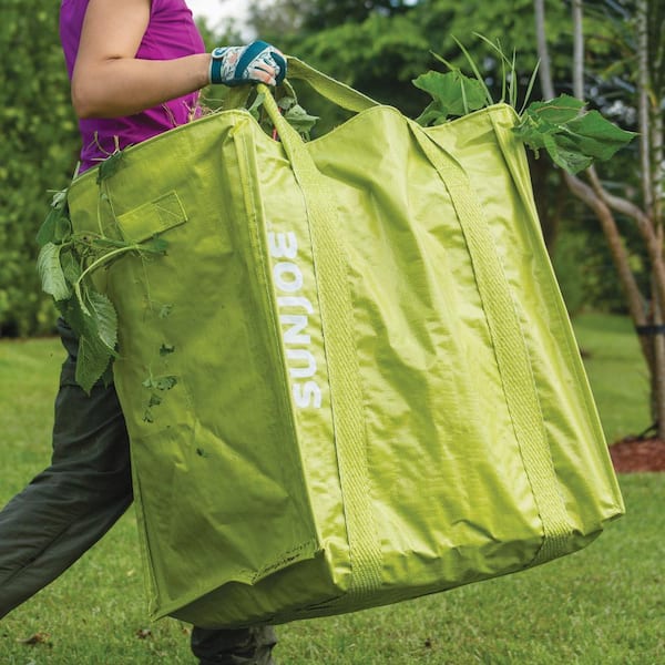 Person carrying the jumbo garden bag with debris in it.