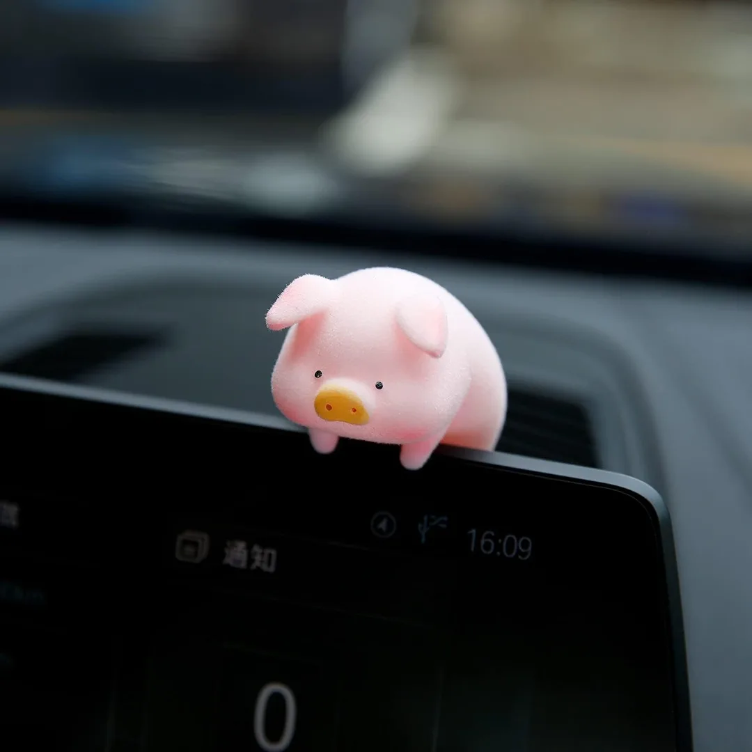 Up close image of LuLu the Lucky Piggy Companion sitting on top of a laptop screen