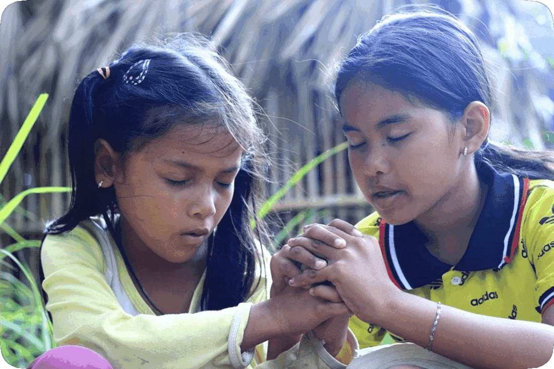 Picture of two girls in prayer together.