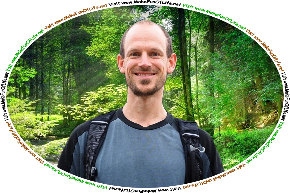 Picture of a happy smiling man standing among leafy green trees in a wilderness area, and the words, ‘Visit www.MakeFunOfLife.net.’