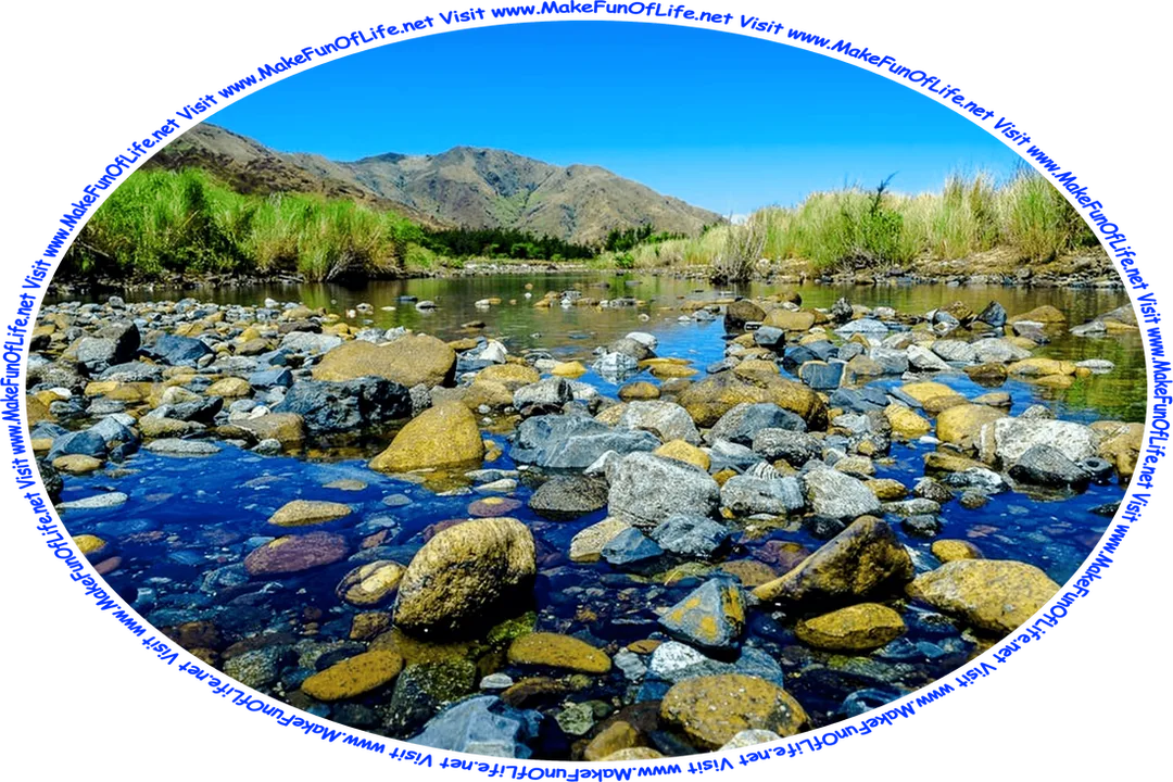 Picture of clear shallow water with large numbers of river stones partially submerged it, tall green grass along its banks, hills in the distance, a clear blue sky above, and the words, ‘Visit www.MakeFunOfLife.net.’