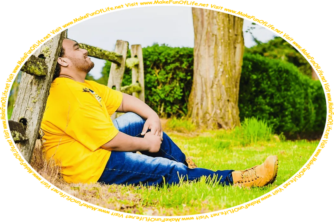 Picture of a happy smiling man sitting in green grass and leaning against an old wooden fence, and the words, ‘Visit www.MakeFunOfLife.net.’