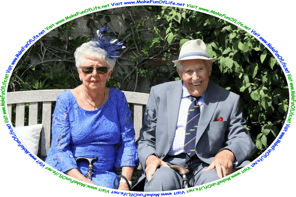 Picture of a happy, smiling older married couple outside on a bright, sunny day, seated on a wooden bench with a brick wall covered in green leafy plants behind them, and the words, ‘Visit www.MakeFunOfLife.net.’