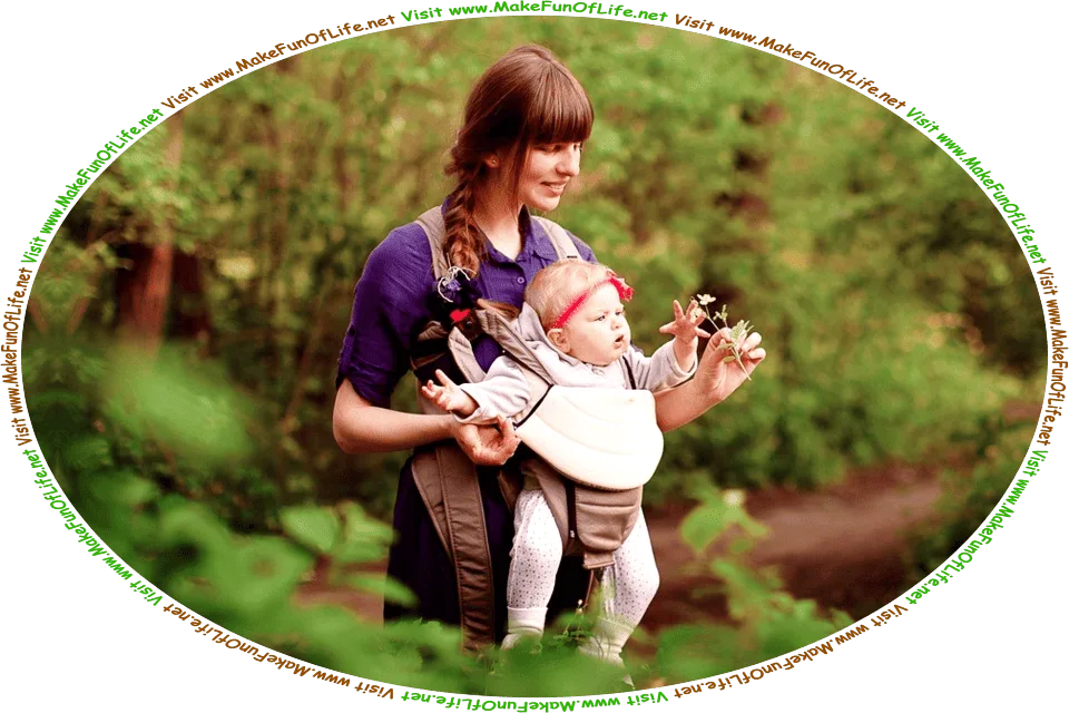Picture of a happy smiling mother holding a plant to show to her curious young infant child, while the two are outdoors in a wilderness of green leafy trees and dirt footpaths, and the words, ‘Visit www.MakeFunOfLife.net.’