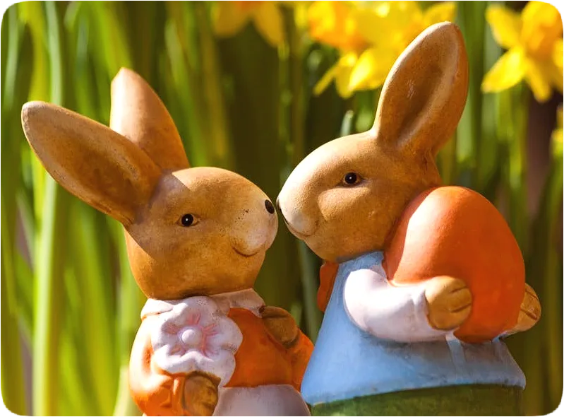 Picture of a pair of happy smiling rabbit figurines with noses touching.