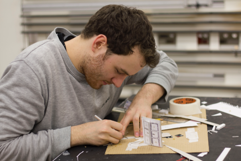A set designer builds a scale model.