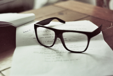 a pair of glasses sit on a script