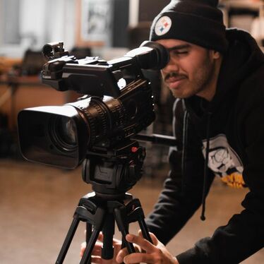 A student focus a camera on the action.