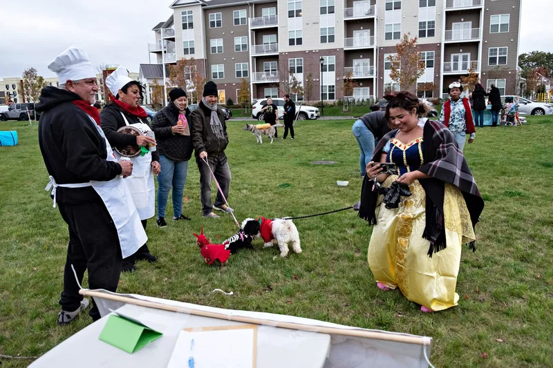 photo of people and dogs enjoying a Halloween dog costume parade