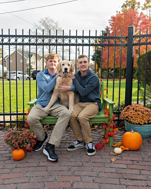 photo of a dog with two young men