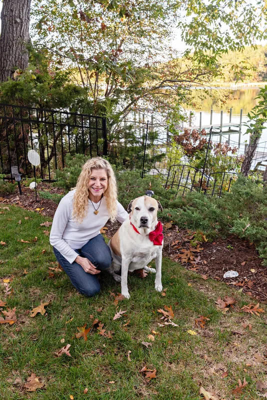 A photo of a brown and white hound mix dog and her owner, a white woman. The photo is by Laura Pea Photography, a Long Island based pet photographer. 