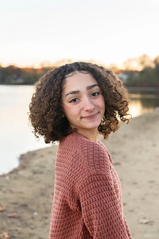 color photo of a teenage girl  looking at the camera over her shoulder. Portrait taken by Long Island pet photographer Laura Pea Photography