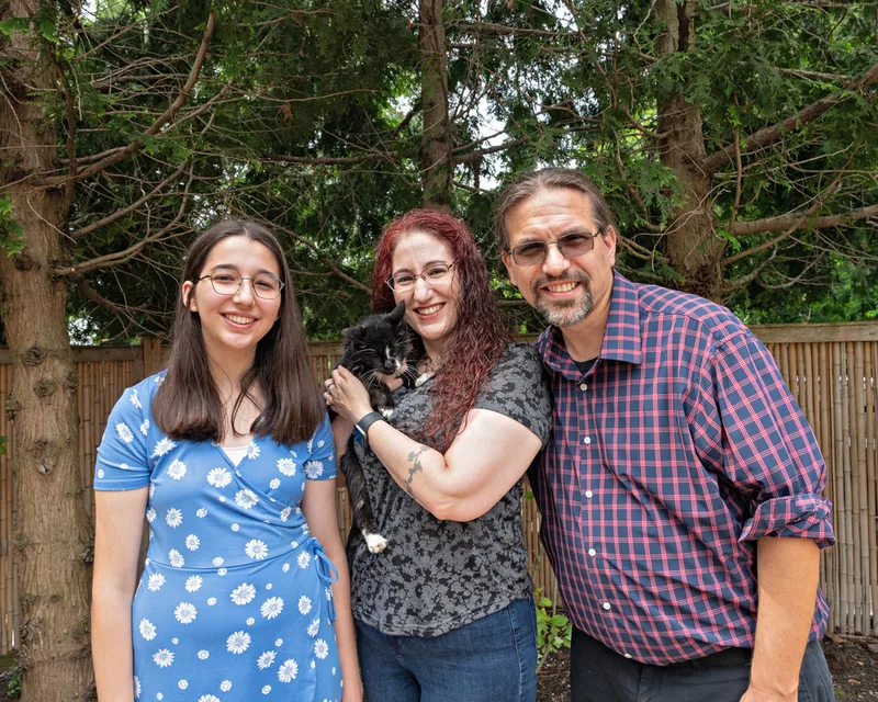 Color photo of a family with their cat at the Middle Country Public Library Nature Explorium. The photo was taken by Laura Pea Photography, a Long Island pet photographer. 