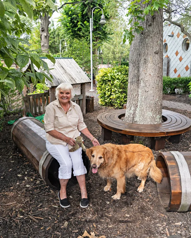 Color photo of a woman and her dog at the Middle Country Public Library Nature Explorium. The photo was taken by Laura Pea Photography, a Long Island pet photographer. 