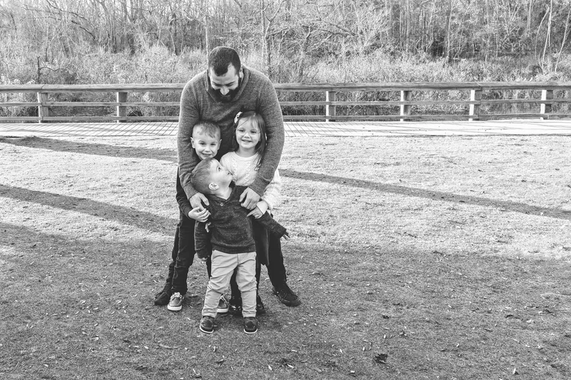 Black and white photo of an uncle with his niece and nephews