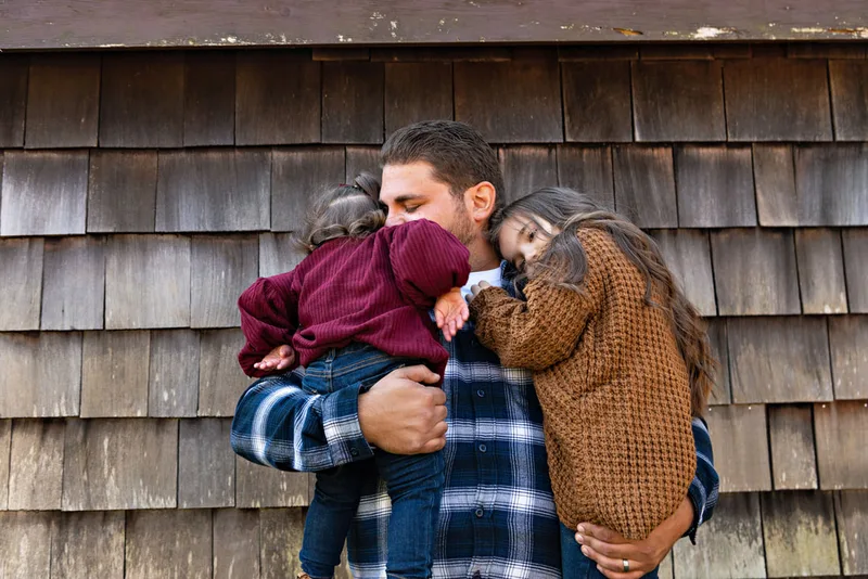 photo of a dad hugging his daughters