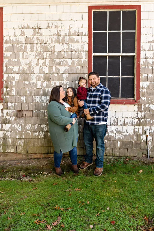 photo of a family of four in front of a house
