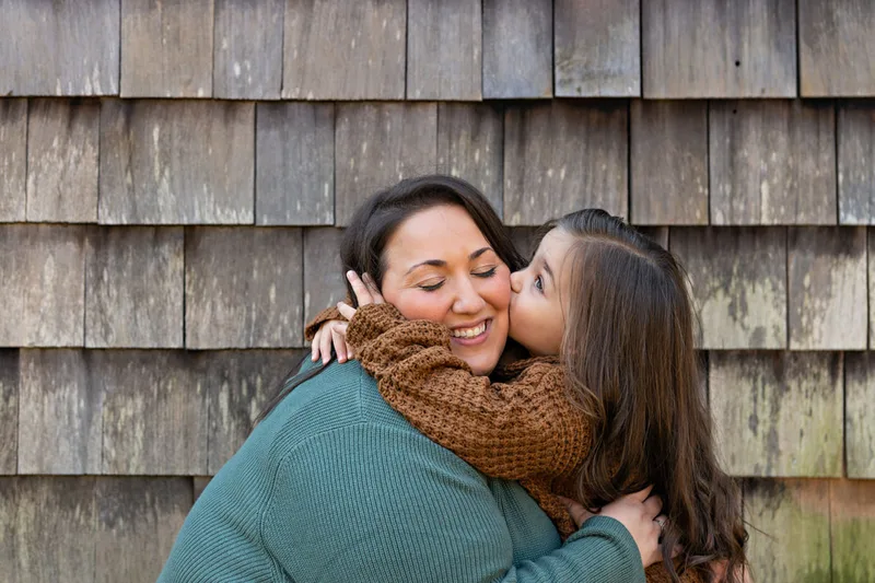 photo of a mom being kissed on the cheek by her daughter