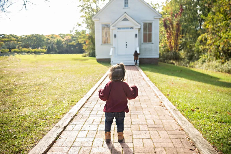 photo of a young girl walking toward her older sister